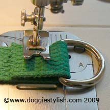 a close up of a sewing machine with a green piece of cloth on top of it