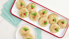 cookies decorated with holly leaves are on a plate