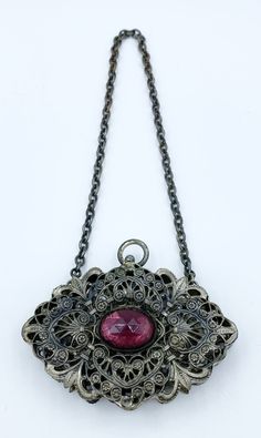 Charming Art Nouveau silver-tone filigree change purse bezel-set with large oval amethyst glass stone. Purse has hinged clasp that opens in the back.  Measures - 3 x 2 inches, 7.62 x 5.08 cm CONDITION:  Some age related discoloration to the metal. The stone is a bit cloudy. See pictures for details and if you like what you see here please take a moment to check out the other vintage purses, chatelaine purses and change purses I have for sale. I combine shipping costs for multiple purchases. Victorian Formal Jewelry With Oxidized Finish, Victorian Oval Jewelry For Evening, Antique Medallion Jewelry For Evening, Ornate Jewelry With Large Pendant For Formal Occasions, Ornate Hinged Jewelry For Gifts, Ornate Filigree Jewelry For Evening, Formal Oval Jewelry With Oxidized Finish, Ornate Evening Jewelry With Intricate Design, Art Nouveau Silver