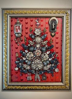 a christmas tree made out of buttons and other items in a frame on the wall