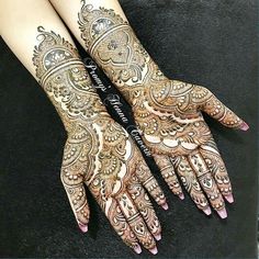 two hands with henna tattoos on them