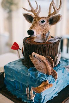 there is a cake decorated to look like a deer and two fish on top of it