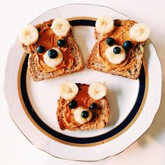 toast with peanut butter, bananas and blueberries in the shape of a bear face