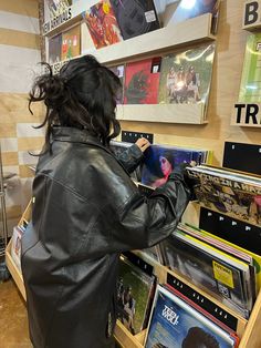 a woman looking at records in a record store