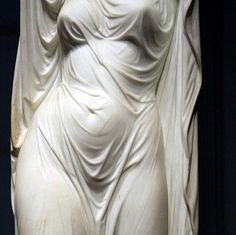 a white statue is shown in front of a black background