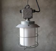 a white light hanging from a metal cage