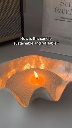 a candle that is on top of a white plate with the words how is this candle sustainable and retrifiable?