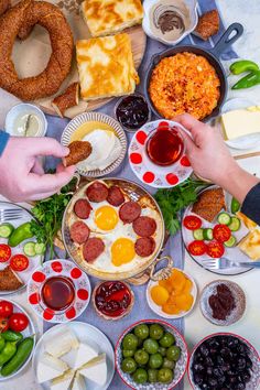 a table full of food including bread, olives, cheese and other condiments