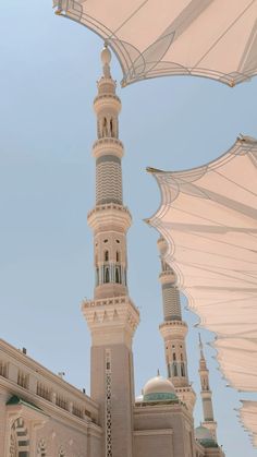 a large white building with a clock on it's side and an umbrella over the entrance