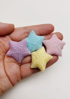 three small crocheted stars in the palm of someone's hand