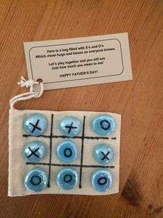 a tic - tac - toe game on a wooden table next to a card