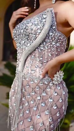 a woman in a dress that has some kind of beading on it and is posing for the camera