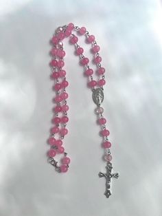 *Hamdmade Rosary necklace  *Pink glass beads and silver charms  *Lobster claw closure *Cross and Virgin Mary charms Cross Necklace Pink, Cross Necklace Beads, Cross Beaded Necklace, Pink Round Beads Crystal Necklaces For Jewelry Making, Pink Crystal Necklaces With Round Beads For Gifts, Pink Necklaces With Polished Beads For Gifts, Pink Spiritual Beaded Necklace With Gemstone Beads, Spiritual Pink Crystal Necklaces With Round Beads, Pink Faceted Beads Necklace For Healing