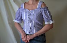 Vintage check print folk blouse, from the 1990s era Women's cold shoulder dirndl blouse, featuring a purple and white check pattern and white lace decorations. Closes with silver metal buttons in the front, adjusted with a tie at the back of the waist Material - missing tag, probably a cotton/polyester blend Size - 38 DE which is 8 US, shown on size 38 DE/ 8 US Approximate Measurements (taken when top is lying flat, double armpit to armpit and bottom): Shoulders - from 20 inches / 50.8 cm stretc Spring Gingham Top With Square Neck, Gingham Square Neck Top For Spring, Spring Gingham Square Neck Top, Retro Gingham Blouse For Spring, Fitted Gingham Blouse With Puff Sleeves, Spring Retro Gingham Blouse, Vintage Square Neck Tops For Spring, Vintage Cotton Blouse With Square Neck, Vintage Square Neck Blouse For Spring