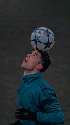 a man balancing a soccer ball on his head