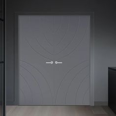 an open door in the middle of a room with wood flooring and gray walls