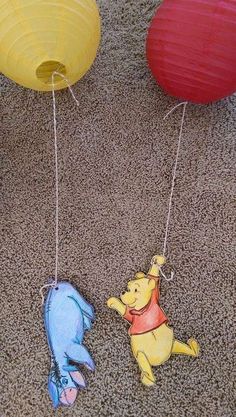 winnie the pooh and piglet paper lanterns hanging from strings on carpeted floor