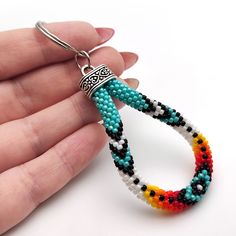 a hand holding a colorful beaded key chain