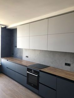 an empty kitchen with black and white cabinets