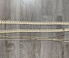 two pieces of rope on top of a wooden floor next to each other with holes in them