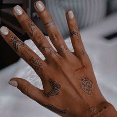 a person's hand with tattoos on it, and the palm of their left hand