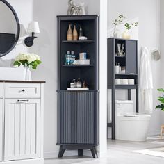 a bathroom with a toilet, sink and cabinet in it's center area next to a mirror