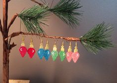 beaded christmas ornaments hanging from a tree branch