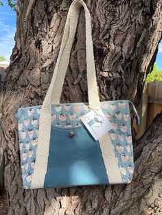 This beautiful oxbow tote is made from a irresistible light blue Japanese canvas with quaint strawberries. It's been quilted with a nice pattern of circles and 1/8th inch lines. Two large slip pockets front and back. One made with a handwaxed canvas and the other with 100% leather . Nice sturdy woven strapping provides fashionable details. A easy slide zipper opens the bag on top. Inside it is lined with a cool blue linen and several more pockets. Handmade and one of a kind! Light Blue Bags With Zipper Pouch For Everyday Use, Blue Quilted Shoulder Bag For Everyday Use, Blue Quilted Tote Shoulder Bag, Blue Quilted Shoulder Bag For Daily Use, Blue Quilted Bags For Daily Use, Daily Use Blue Quilted Bags, Handmade Light Blue Bags For Everyday Use, Oxbow Tote, Tula Pink Fabric