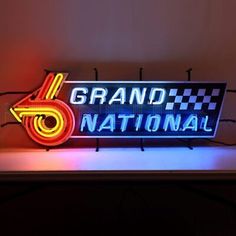 a neon sign that says grand national with a checkered flag on it's side