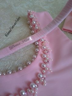 a pink dress with pearls on it