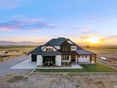 an aerial view of a house in the middle of nowhere with mountains in the background