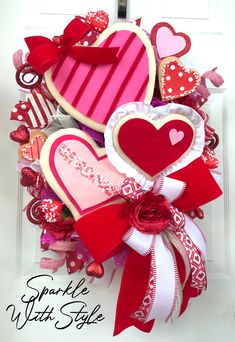 valentine's day wreath with heart shaped cookies and ribbons on the front door for decoration