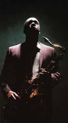 a man in a suit and tie holding a saxophone