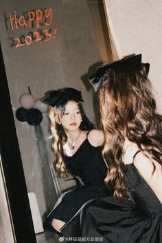 a woman sitting in front of a mirror with her hair styled to look like a witch