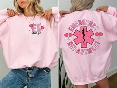 two women wearing pink sweatshirts with the words emergency department on them and an embellished heart