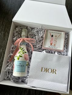 a bottle of dior in a white box with a pink ribbon around the neck