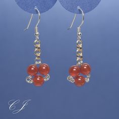 "I handmade these red carnelian earrings just for you. They are round gemstone beads, but they are arranged to resemble little red hearts. These cute little earrings will make a delightful addition to your Summer and Fall accessory collection. Ancient Byzantine and Assyrian cultures used Carnelian to foster courage, and so can you. Silver and gold filled jump rings provide a subtle contrast.  Please note: Gemstone beads are natural and therefore have slight variations in texture and color. The b Elegant Carnelian Dangle Earrings, Red Agate Earrings With Natural Stones, Handmade Agate Round Bead Earrings, Round Beaded Earrings With Natural Stones As Gift, Round Natural Stones Beaded Earrings As Gift, Elegant Carnelian Earrings For Gift, Elegant Carnelian Earrings Gift, Carnelian Dangle Earrings With Natural Stones, Carnelian Gemstone Dangle Earrings