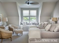 a living room filled with furniture next to a window covered in white blankets and pillows