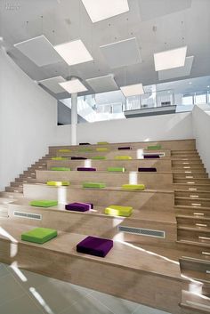 an empty room with stairs and colorful rugs on the floor