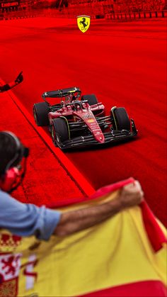 a man holding a flag next to a race car