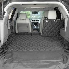 the back end of a car with its cargo area covered in black tarp and an open trunk