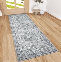 an area rug is on the floor in front of a door with a potted plant