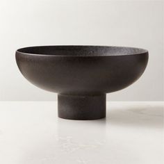 a black bowl sitting on top of a white table