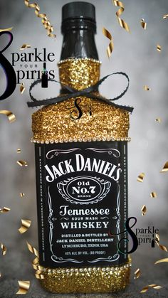 a bottle of jack daniels whiskey is surrounded by confetti and gold streamers