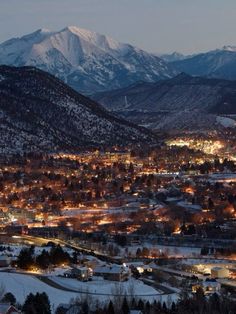 the city lights are lit up in the mountains