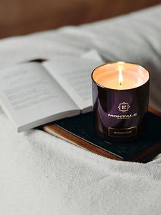 an open book and candle on a bed