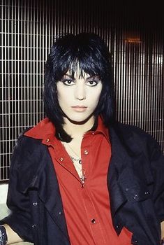 a man with black hair wearing a red shirt