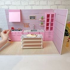 a doll house with pink furniture and accessories in the front door open to show it's kitchen