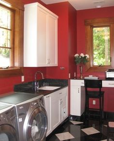 a washer and dryer in a room with red walls