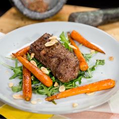 a white plate topped with carrots and meat